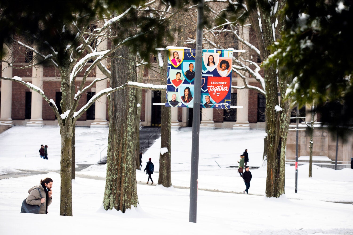 Students walking in the snow near Widener Library