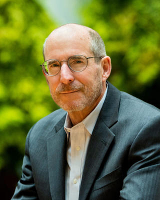 Jim Stock is smiling with trees in the background