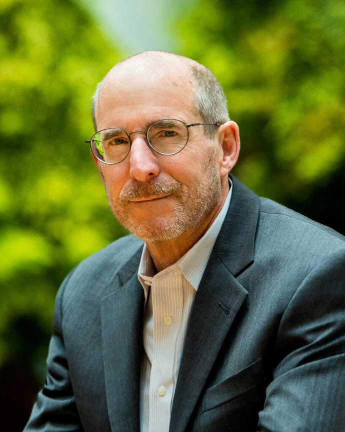 Jim Stock is smiling with trees in the background